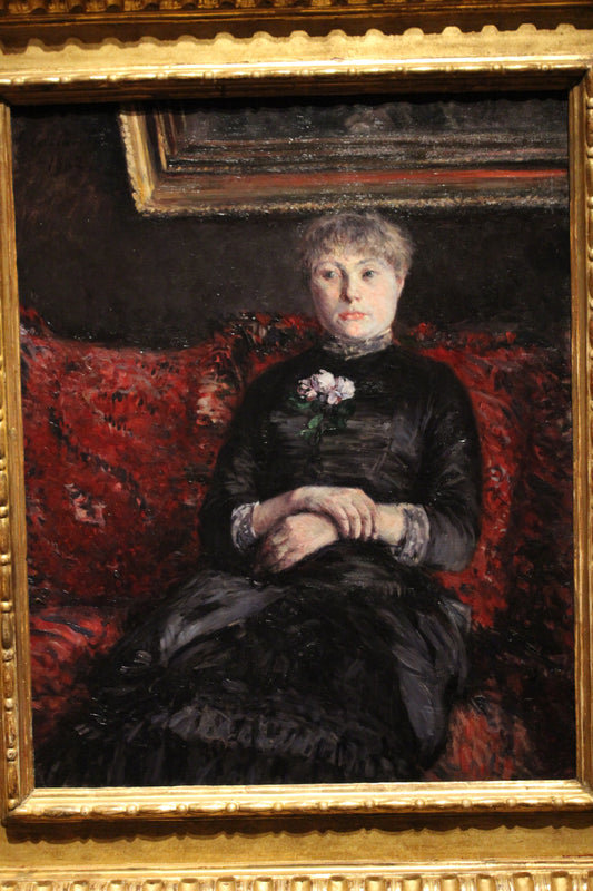 Reproduction du tableau « Femme assise sur un canapé à fleurs rouges - Gustave Caillebotte » par Alpha Reproduction en peinture à l’huile